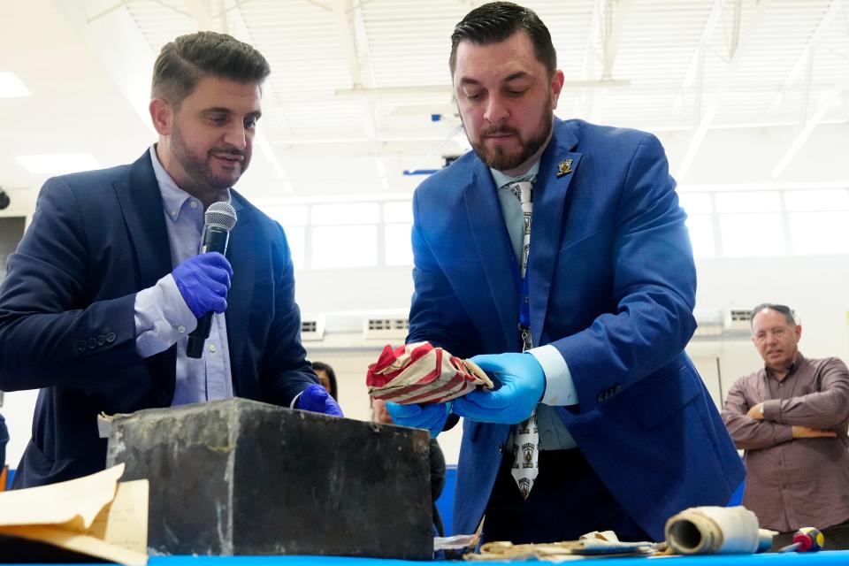 Superintendent Matthew Perrapato removes a bible wrapped in an American flag from the time capsule, beside Little Ferry Mayor Mauro Raguseo, Sunday, March 3, 2024.