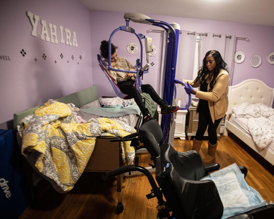 Marcia Campbell, coordinator at Jawonio's Johansen Home in Monsey, uses a lift to get Yahira Abreu from her bed to a wheelchair Nov. 28, 2023. Yahira is one of eight adults with severe disabilities living at the group home run by Jawonio, a non-profit that serves those with intellectual and developmental disabilities, and people with chronic medical needs. As wages for group home workers are set by the state, jobs remain empty and group homes around the state are being shuttered.