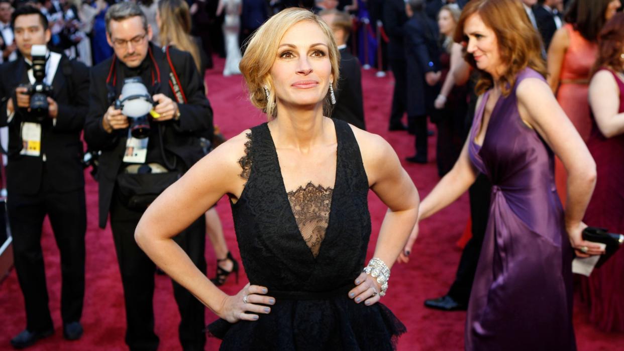  Julia Roberts at the Oscars 2014 in one of the best red carpet looks of the 2010s, smiling and looking up at the camera . 