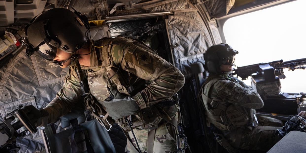 US Army CH-47 Chinook helicopter gunners scan the desert while transporting troops on May 26, 2021 over northeastern Syria.
