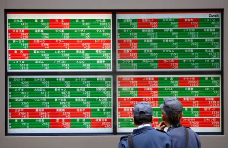 FILE PHOTO: Men look at stock quotation boards outside a brokerage in Tokyo, Japan, December 5, 2018. REUTERS/Issei Kato