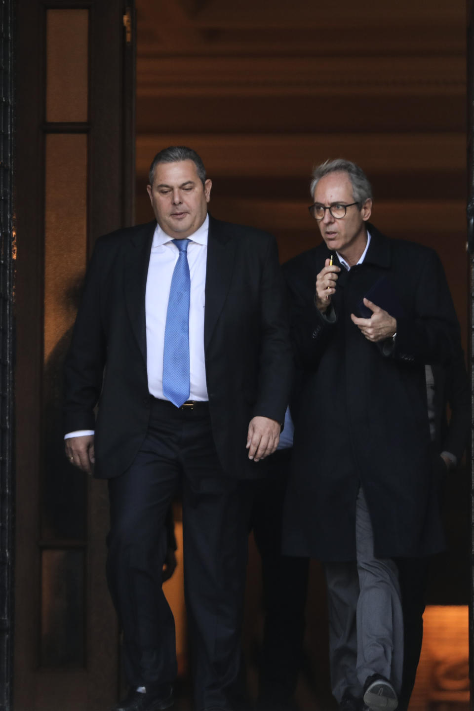 Greek Defense Minister Panos Kammenos, left, leaves Maximos mansion following a meeting with Greece's Prime Minister Alexis Tsipras, in Athens, Sunday, Jan. 13, 2019. Greek defense Minister Kammenos, leader of the right-wing populist Independent Greeks party, is vehemently opposed to a deal with neighboring Macedonia over its state name. (AP Photo/Yorgos Karahalis)