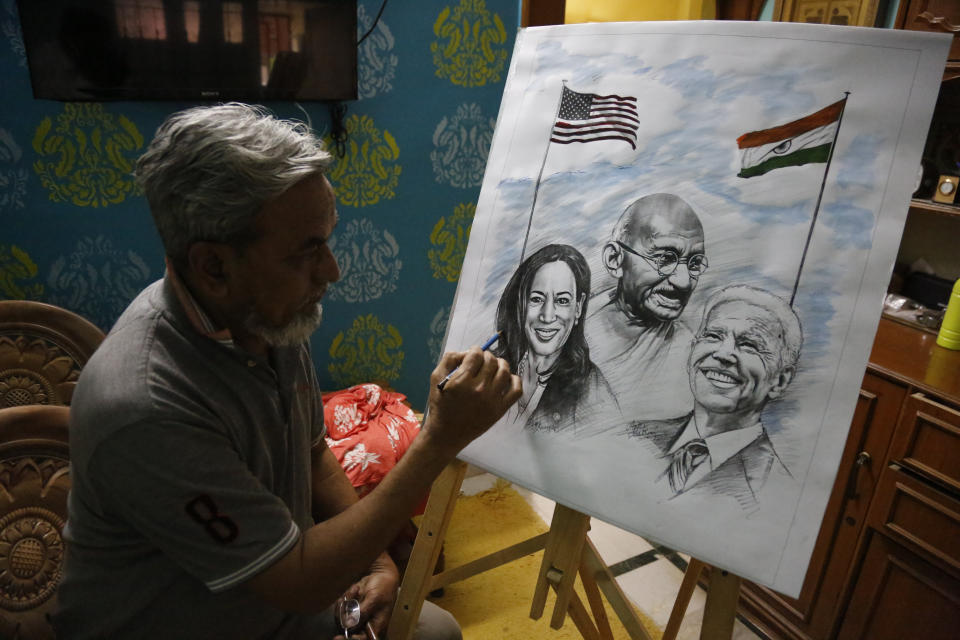 An Indian artist Aejaz Saiyed gives finishing touch to an art work featuring U.S.President-elect Joe Biden, Vice President-elect Kamala Harris and Indian freedom fighter Mahatma Gandhi, ahead of Biden's inauguration ceremony, in Ahmedabad, India, Wednesday, Jan. 20, 2021. The inauguration of Biden and Harris is scheduled be held Wednesday. (AP Photo/Ajit Solanki)