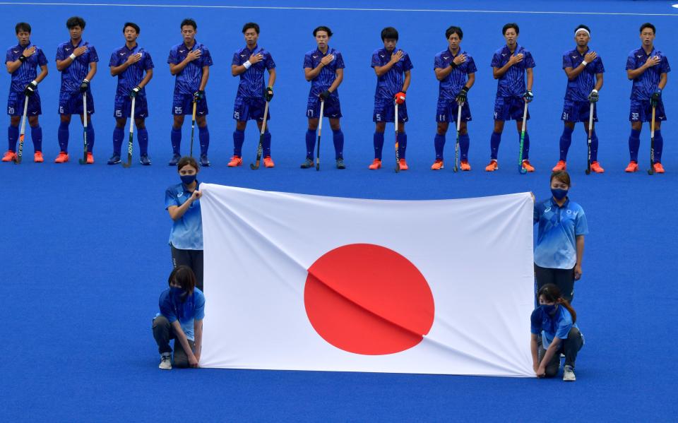 <p>Players of Japan listen to their national anthem before their men's pool A match of the Tokyo 2020 Olympic Games field hockey competition against New Zealand, at the Oi Hockey Stadium in Tokyo on July 27, 2021. (Photo by Luis Acosta / AFP)</p> 