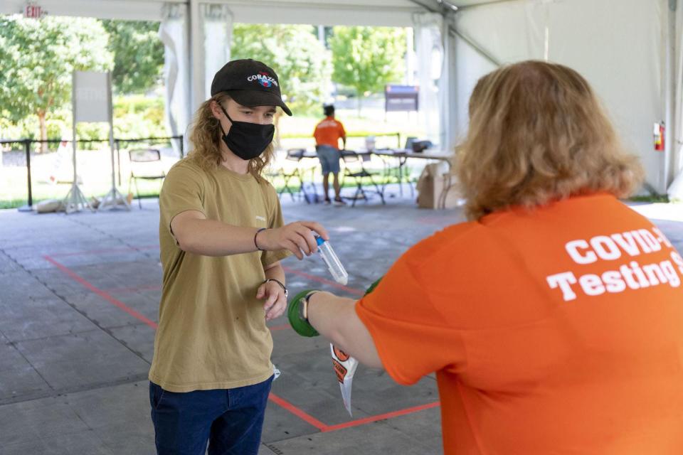 Graduate student Brett Cain completes COVID-19 saliva testing on Tuesday, July 7, 2020, in a tent on the University of Illinois at Urbana-Champaign campus.