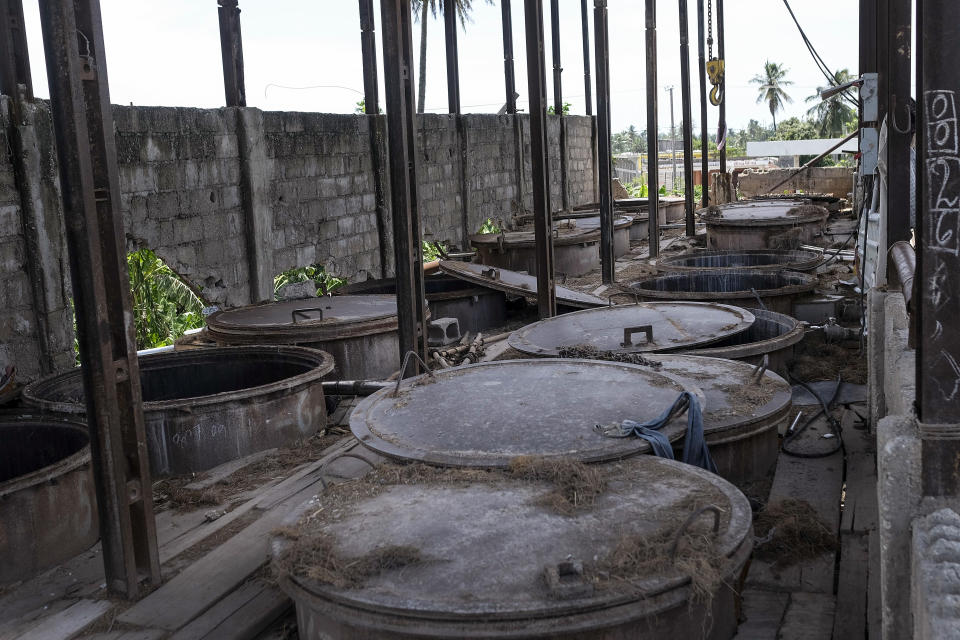 Containers sit idle at the Etheuss Vetiver oil factory after it was made inoperable by the 7.2 magnitude earthquake in Les Cayes, Haiti, Thursday, Aug. 19, 2021. Many of the factories that contributed to one of Haiti's top exporter, used in fine perfumes, cosmetics, soaps and aromatherapy, are now inoperable. (AP Photo/Matias Delacroix)