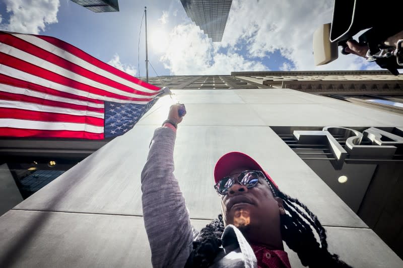 <cite>2024年5月31日，川普的支持者在川普大廈外揮舞一面倒掛的美國國旗。（美聯社）</cite>