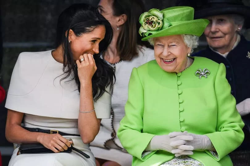 Queen Elizabeth II sits and laughs with Meghan, Duchess of Sussex during a ceremony to open the new Mersey Gateway Bridge on June 14, 2018