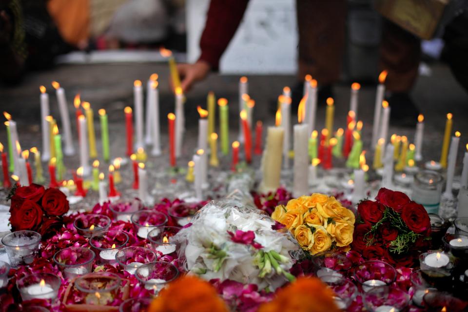 An Indian lights a candle as she mourns the death of a young woman who was recently gang-raped in a moving bus in New Delhi, India, Sunday, Dec. 30, 2012. (AP Photo/Altaf Qadri)