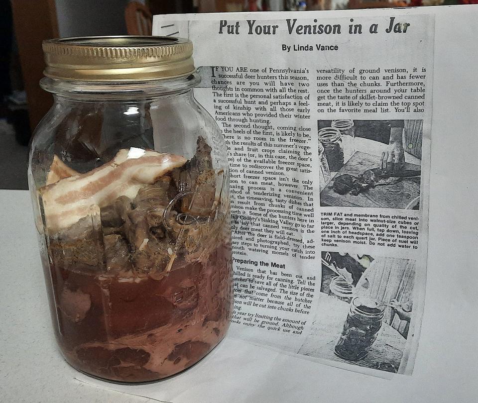 A jar of canned venison with a slice bacon for extra flavor sits beside a photo copy of a December 1981 Game News article about canning deer meat.