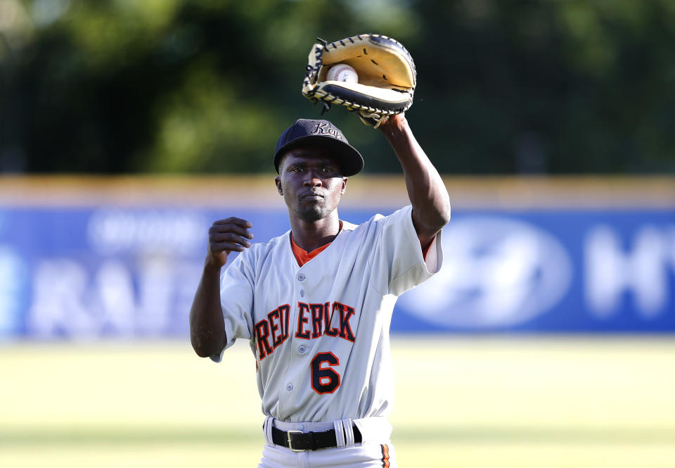 Frederick Keys catcher Dennis Kasumba warms up for the team's baseball game against the Trenton Thunder, Tuesday, July 4, 2023, in Trenton, N.J. Kasumba, from Uganda, dreams of reaching the major leagues someday. The 19-year-old catcher had a chance to play for the Frederick Keys of the MLB Draft League this past month. (AP Photo/Noah K. Murray)