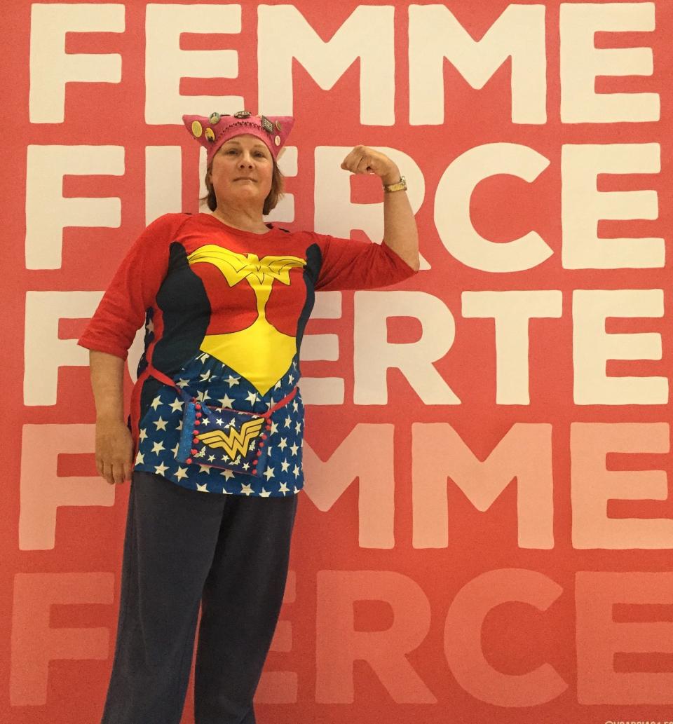 Karen Dunnam, 60, posed in front of a poster at the Women's Convention wearing her fall "pussy hat." (Photo: Catherine Pearson/HuffPost)