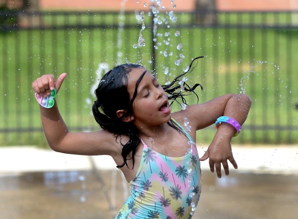 Payzlie West, 6, of Springfield cools down from this week's hot temperatures at  the splash pad at Comer Cox Park Tuesday, August 22, 2023.