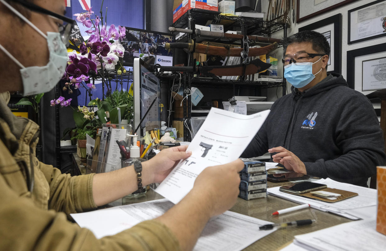 David Liu, owner of a gun store, takes an order from a customer in Arcadia, California, on Sunday. (Photo: ASSOCIATED PRESS)