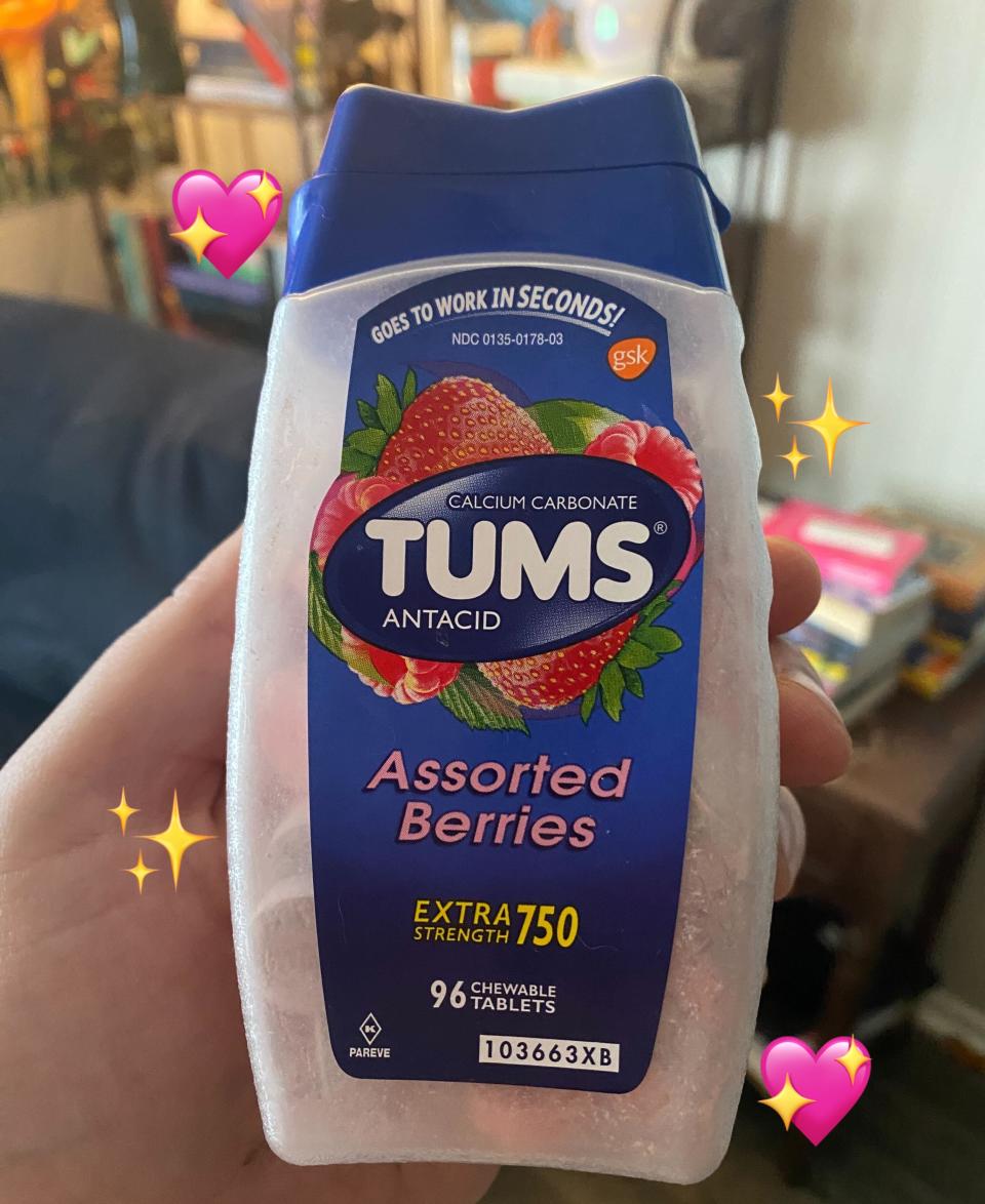 Hand holding a bottle of Tums Assorted Berries antacid tablets