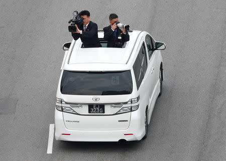 FILE PHOTO: Official cameramen follow the motorcade of North Korean leader Kim Jong Un travels towards Sentosa for his meeting with U.S. President Donald Trump, in Singapore June 12, 2018. REUTERS/Edgar Su/File Photo