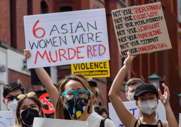 Asian women at a protest in Washington's Chinatown on March 27, 2021. One woman holds a sign that reads 