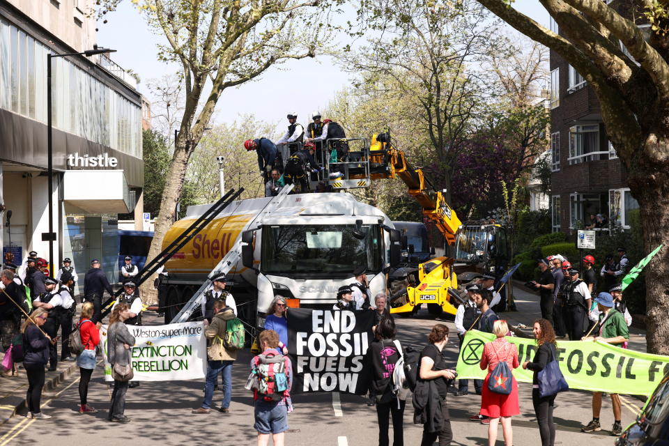 Police officers try to remove Etienne Stott, a former Olympian, and other activists from Extinction Rebellion who occupied an oil tanker during a protest.