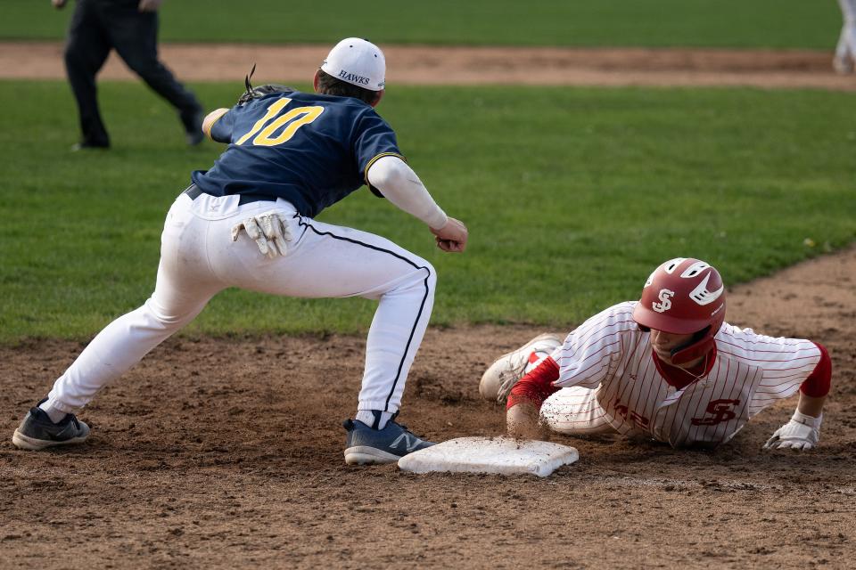St. John's Conor Secrist slides back to first before the throw to Xaverian's Nolan Rappoli in the bottom of the fifth.