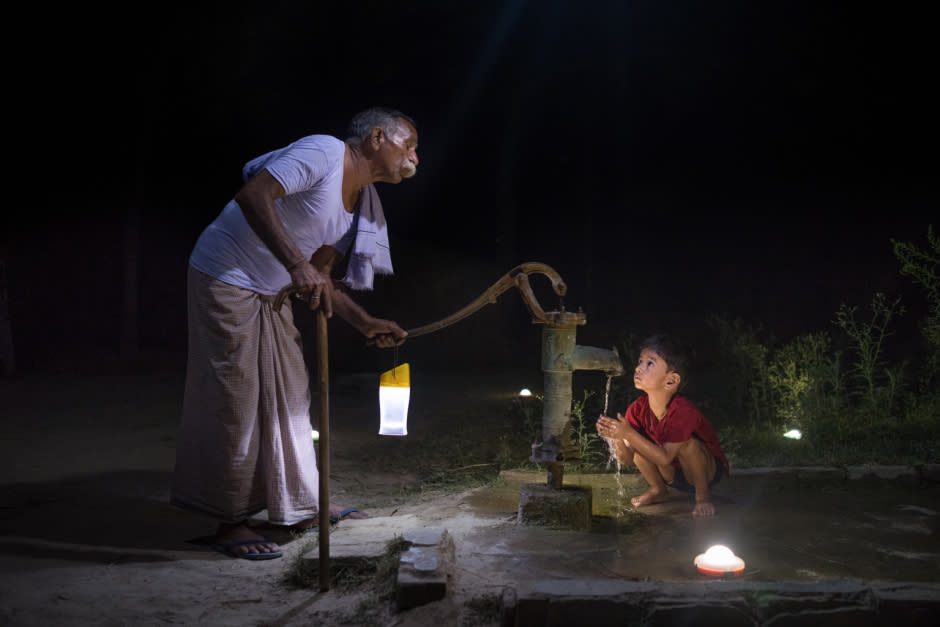 Guru Deen Shukla, is a retired state government worker of 75 years. In the photo, he pumps water for his grandson outside of his home in Pevre Badhai, India.