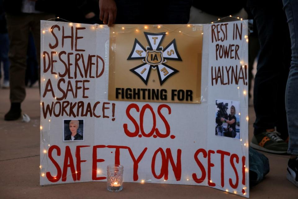 A woman displays a sign calling for workplace safety at the vigil (REUTERS)