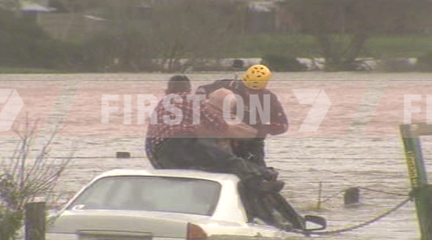 Man winched to safety by airwing after his vehicle became stuck in rising floodwaters. Photo: 7News