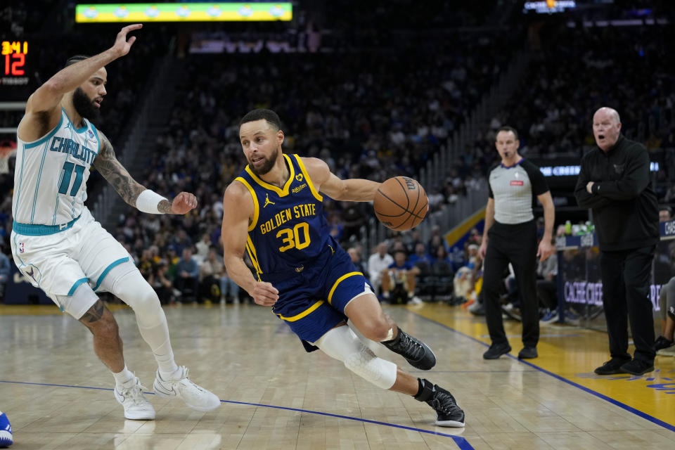 Golden State Warriors guard Stephen Curry (30) drives against Charlotte Hornets guard Cody Martin during the first half of an NBA basketball game Friday, Feb. 23, 2024, in San Francisco. (AP Photo/Godofredo A. Vásquez)