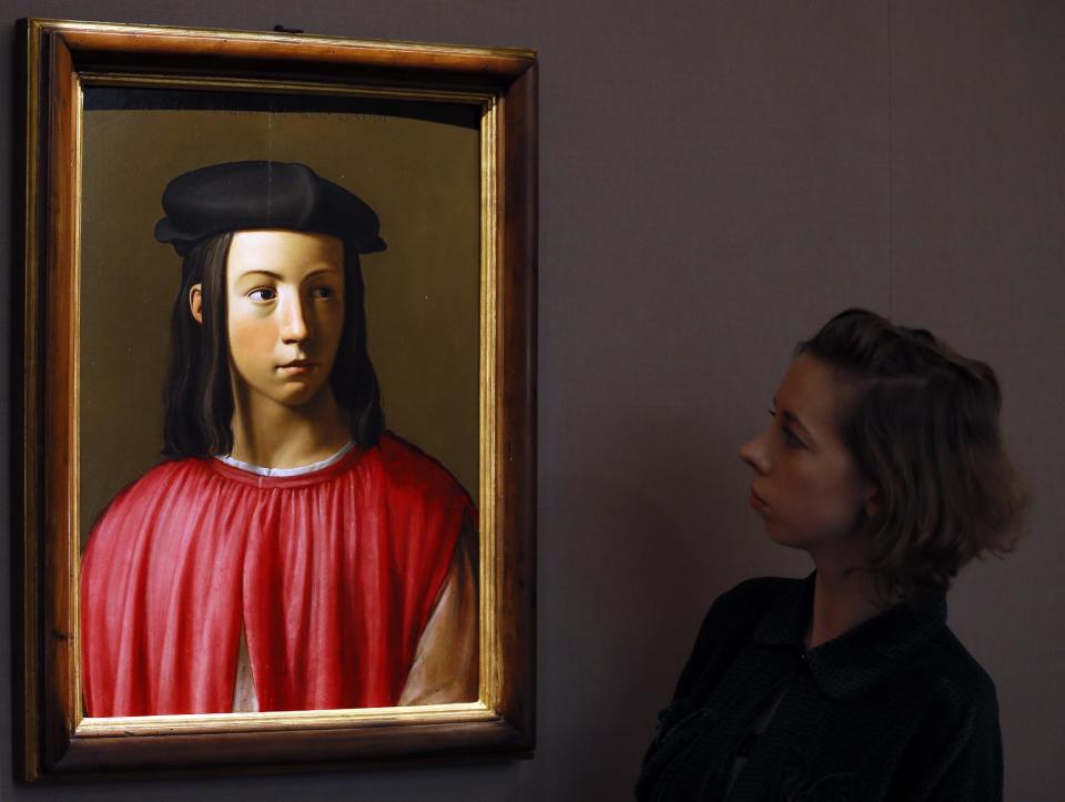 A Sotheby's employee looks at a painting, a portrait of Giovanni Gaddi (1493-1542) which is yet to find a convincing attribution, during a press viewing in London, Friday, Nov. 30, 2012. The painting estimated at 600,000-800,000 pounds (960,500-1,280,500 US Dollars) will go on sale in the evening sale of Old Master Paintings and Drawings on Dec. 5 in London. (AP Photo/Kirsty Wigglesworth)