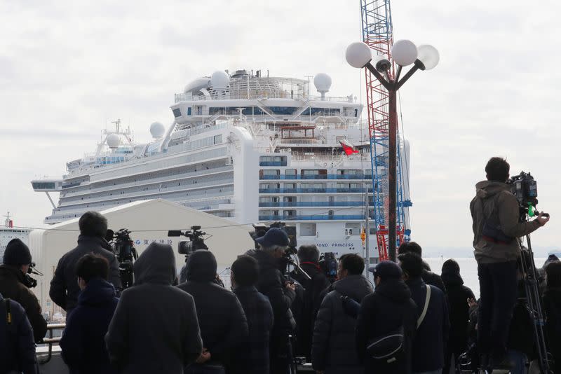 Members of the media look on at the cruise ship Diamond Princess at Daikoku Pier Cruise Terminal in Yokohama, south of Tokyo