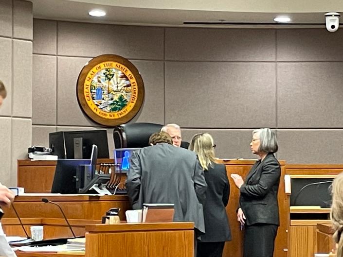 Lawyers speaking to each other and Circuit Judge Peter Brigham at trial