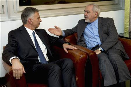 Switzerland's Foreign Minister Didier Burkhalter (L) speaks with his Iranian counterpart Mohammad Javad Zarif during a meeting ahead of talks on Iran's nuclear programme, in Geneva November 23, 2013. REUTERS/Keystone/Martial Trezzini/Pool