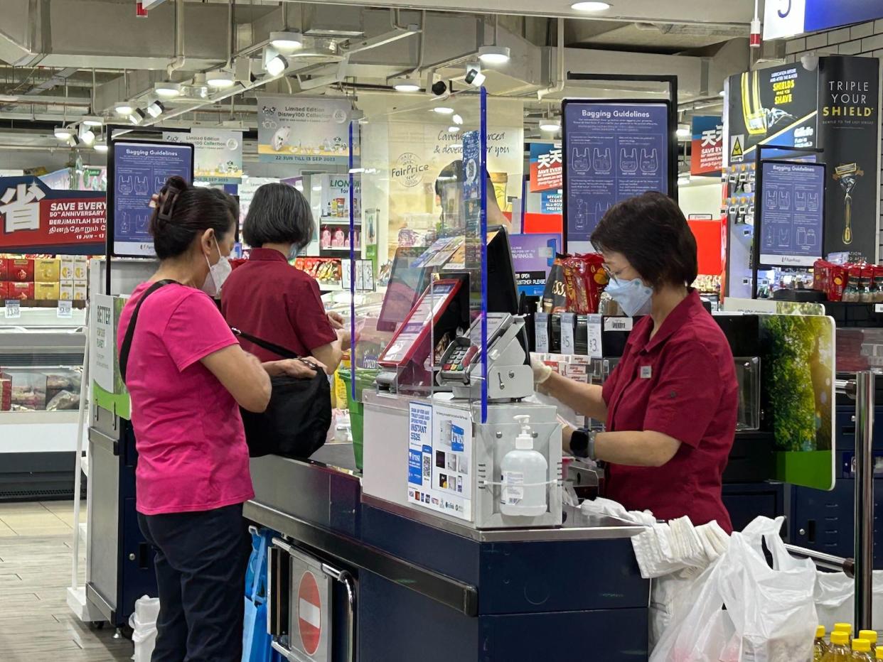 Shoppers express mixed reactions to the implementation of a plastic bag surcharge at NTUC FairPrice at Northpoint City, as customers will now be required to pay five cents for each plastic bag they take.