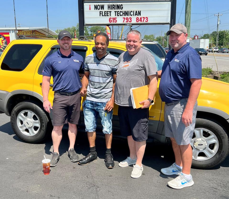 Dion King, second from left, receives a Ford Escape on July 22, 2022, at Tire World in La Vergne, Tenn. From left to right, Ryan Adams, King, Pastor Brian Sweatt of Our Church Ministries and Keith Hewitt