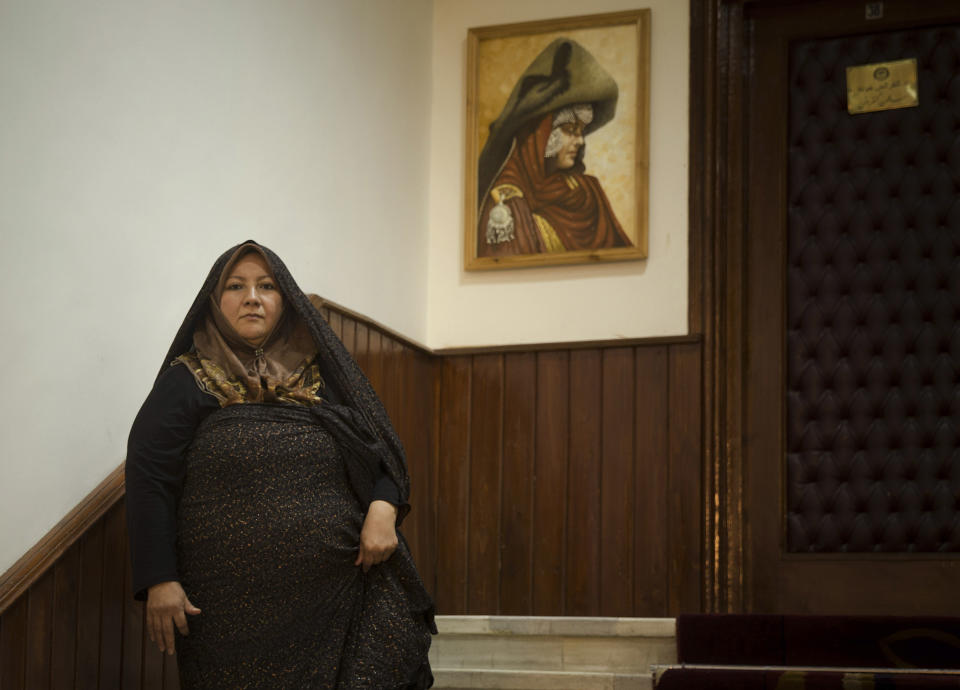 In this Wednesday, March 26, 2014 photo, Afghan lawmaker Kobra Mustafawi from Kabul poses in the entrance hall of the Afghan parliament in Kabul, Afghanistan. Under Afghan law, 20 percent of council member seats are reserved for women, who are also figuring prominently in presidential campaigns. Three presidential hopefuls have taken the bold step of choosing a woman as a running mate, including one of the front-runners. (AP Photo/Anja Niedringhaus)