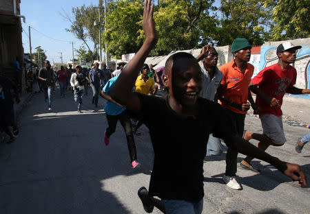 Supporters of ex-president Jean-Bertrand Aristide's Fanmi Lavalas Party run through the street as preliminary results declared businessman Jovenel Moise the official winner of the November 2016 presidential elections in Port-au-Prince, Haiti, January 3, 2017. REUTERS/Jeanty Junior Augustin