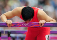 Xiang Liu of China kisses a hurdle after getting injured in the Men's 110m Hurdles Round 1 Heats on Day 11 of the London 2012 Olympic Games at Olympic Stadium on August 7, 2012 in London, England. (Photo by Stu Forster/Getty Images)