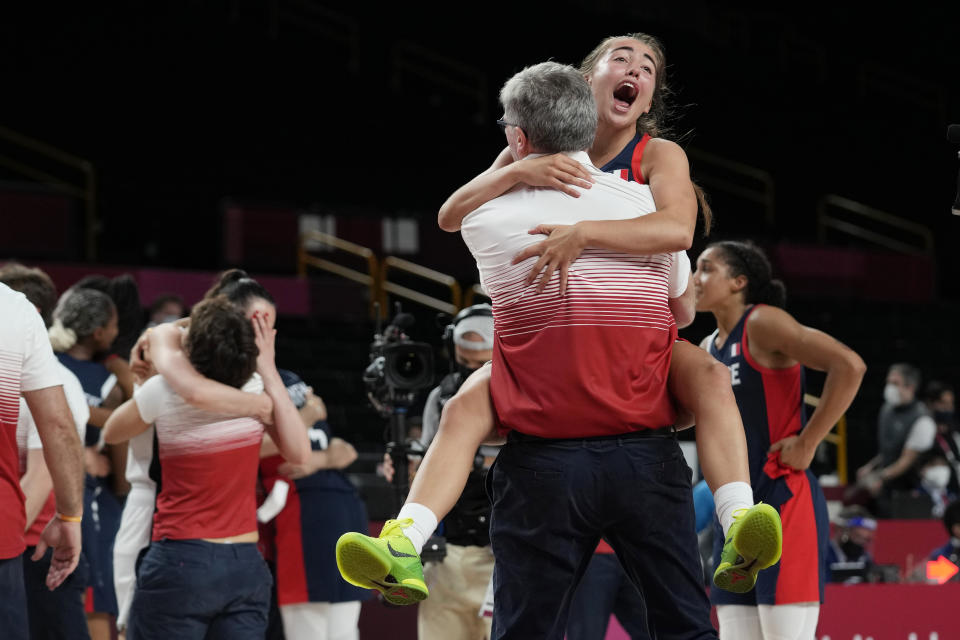 France's Marine Fauthoux (4) leaps into the arms of a staff member as they celebrate the team's win over Serbia in a women's basketball bronze medal game at the 2020 Summer Olympics, Saturday, Aug. 7, 2021, in Saitama, Japan. (AP Photo/Eric Gay)
