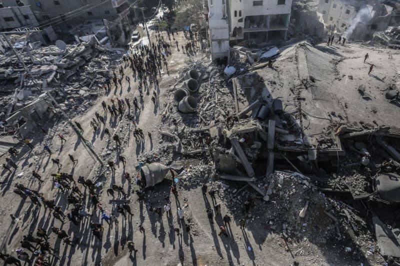 Palestinians gather at the site of Al-Farouq Mosque after an Israeli air strike causing the mosque to be severely ruined along with a number of nearby houses. Mohammed talatene/dpa