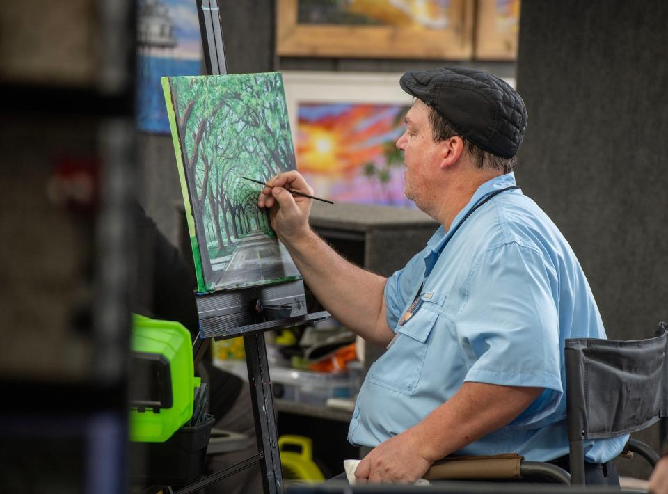 Artist Krel Buckelew works on a painting during the Great Gulfcoast Arts Festival in 2022. The festival continues Nov. 3-5, 2023 in Seville Square.