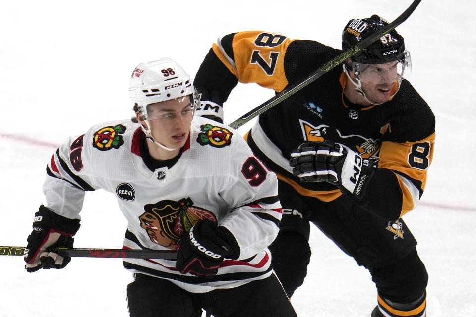 Chicago Blackhawks' Connor Bedard (98) and Pittsburgh Penguins' Sidney Crosby (87) skate during the second period of an NHL hockey game in Pittsburgh, Tuesday, Oct. 10, 2023. (AP Photo/Gene J. Puskar)