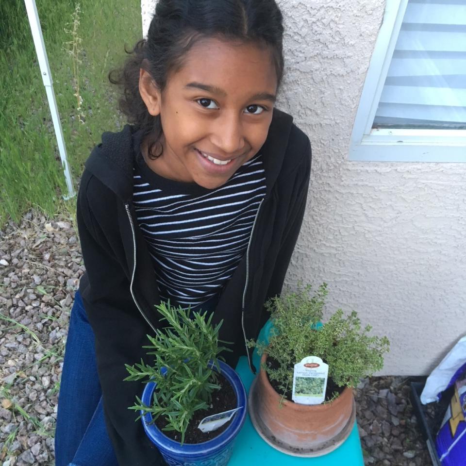 Kumei Norwood plants in her garden for homeschool work