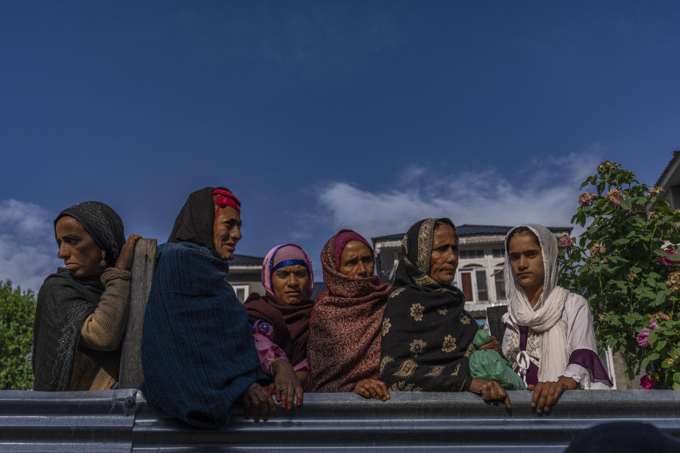 Nomadic Kashmiri women wait for the distribution sweetened rice prepared for devotees outside the forest shrine of Sufi saint Mian Nizamuddin Kiyanwi in Baba Nagri, northeast of Srinagar, Indian controlled Kashmir, Saturday, June 8, 2024. (AP Photo/Dar Yasin)