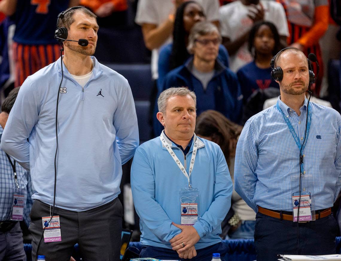 Tyler Zeller, left, was a member of the last North Carolina team to win in Charlottesville in 2012. He is now part of the Tar Heel Sports Network broadcast team, along with Adam Lucas and Jones Angell. The trio was standing for a moment of silence in honor of Eric Montross on Saturday, February 24, 2024 at John Paul Jones Arena in Charlottesville, Va.