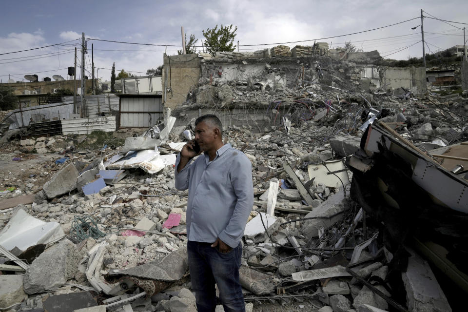 Ratib Matar, a Palestinian whose family home was demolished by Israeli authorities, talks on his mobile phone in the rubble of the home that sheltered 11 people, in the Jabal Mukaber neighborhood of east Jerusalem, Sunday, Jan. 29, 2023. For many Palestinians, the accelerating pace of home demolitions is part of Israel's new ultranationalist government's broader battle for control of east Jerusalem, claimed by the Palestinians as the capital of their future state. Israel says it is simply enforcing building regulations. (AP Photo/Mahmoud Illean)