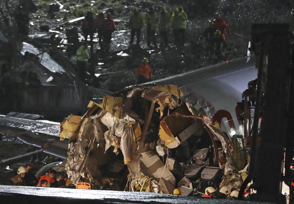 Rescue members work after a plane skidded off the runway at Istanbul's Sabiha Gokcen Airport, Wednesday, Feb. 5, 2020. A plane skidded off the runway Wednesday at Istanbul's Sabiha Gokcen Airport, crashing into a field and breaking into pieces. Passengers were seen evacuating through cracks in the plane and authorities said at least 21 people were injured. (AP Photo)