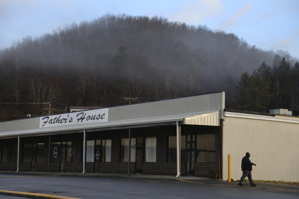 A truck driver walks past Father's House International Church while making a delivery in Bluefield, W.Va., on Tuesday, Jan. 26, 2021. Members of three congregations in a small city in West Virginia’s ‘Trump Country’ face a reckoning over Christianity and the misuse of symbols of their faith in America’s divisive politics. (AP Photo/Jessie Wardarski)
