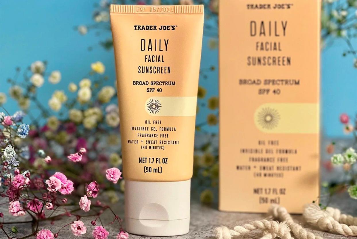 Bottle of Trader Joe's daily facial sunscreen next to flowers