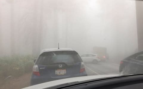 A massive cloud of thick dust spreads across Yosemite Valley after a new rock fall from El Capitan - Credit: Tamara Goode/AP