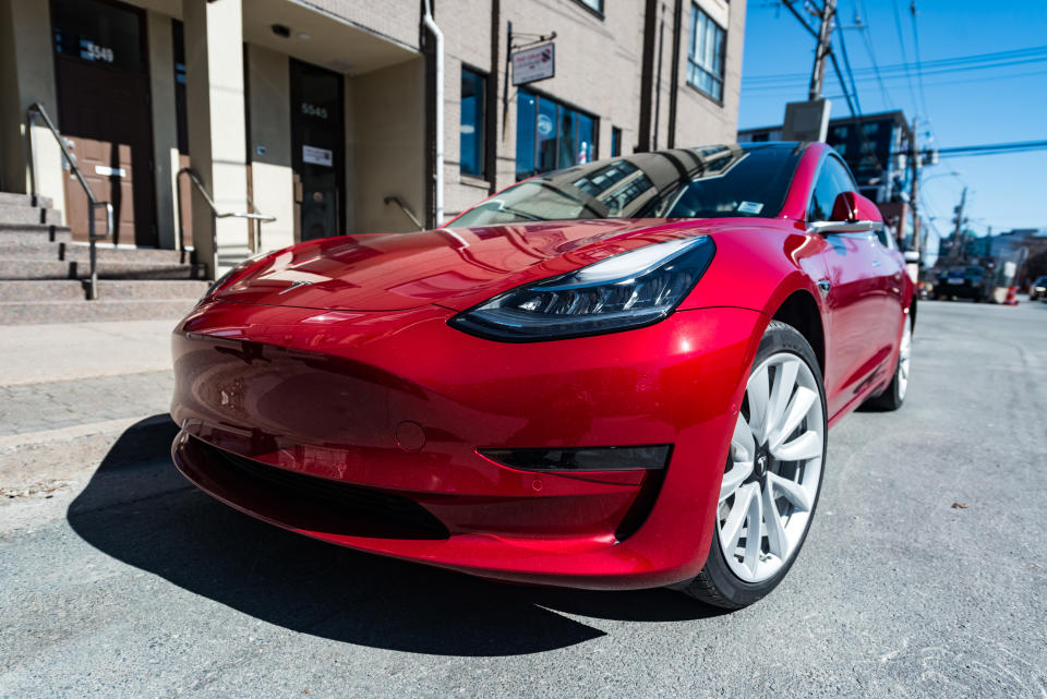 March 26, 2019 - Halifax, Canada - A 2019 red Tesla Model 3 plug-in electric car parked on a city street in downtown Halifax.