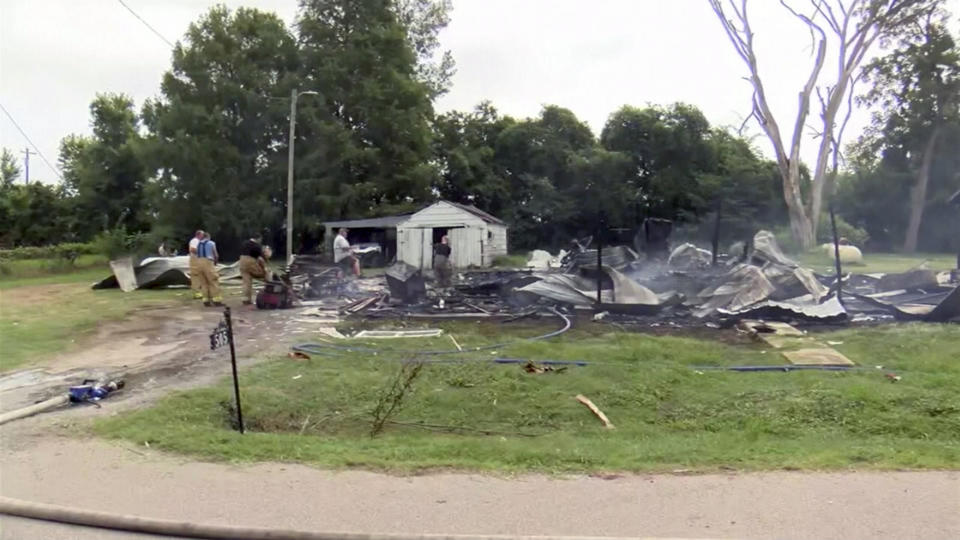 This photo from video by KFVS-TV shows people working the scene of a house explosion in Wyatt Mo., early Monday, Aug. 15, 2022. The house explosion in southeast Missouri has left several people injured and a neighboring home in flames, authorities say. (KFVS TV via AP)